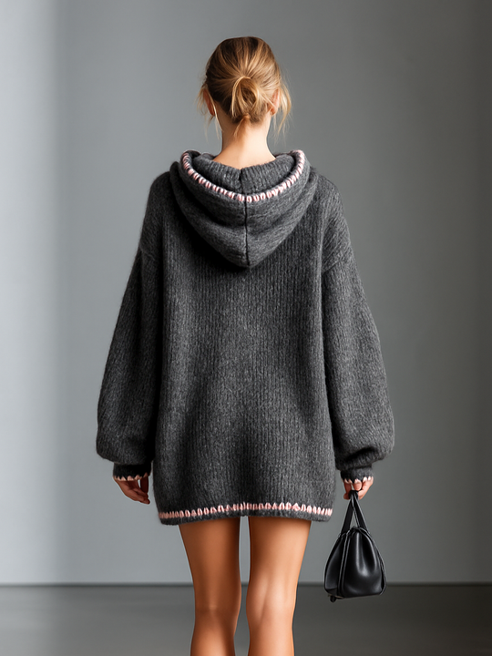 Nahaufnahme des weichen Strickstoffs und rosa Besatzes am Minikleid